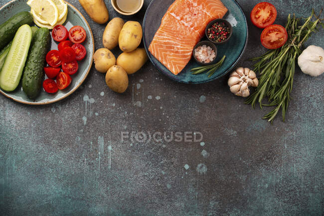 Raw salmon fish fillet, fresh vegetables and herbs - ingredients for cooking healthy meal - foto de stock