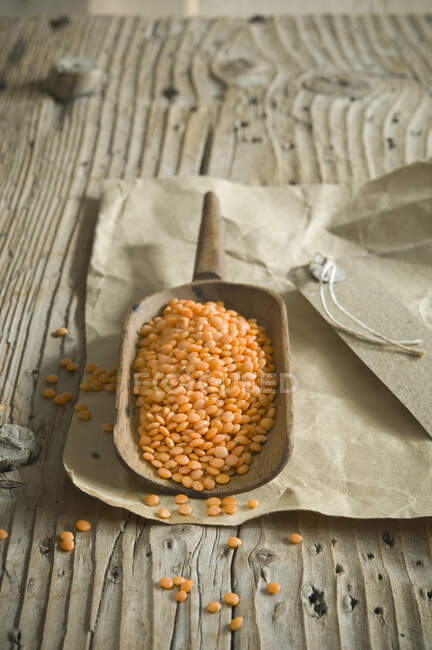 Red lentils in wooden scoop — Stock Photo