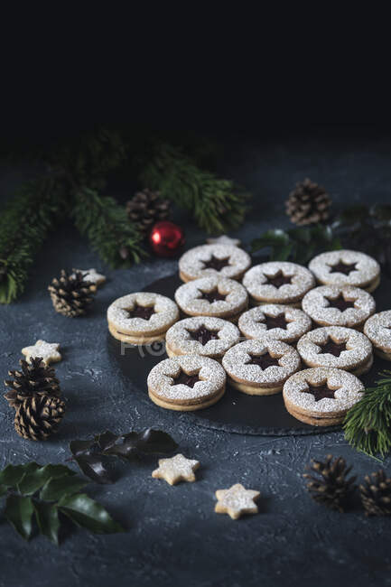 Christmas linzer cookies on tray surrounded with decorations — Fotografia de Stock