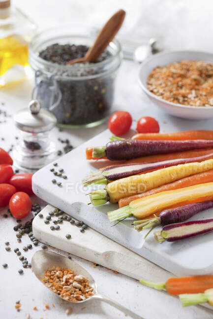 Carote color arcobaleno su un tagliere con condimento dukkah — Foto stock