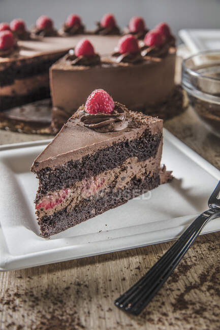 Slice of chocolate raspberry mousse cake on square white plate — Stock Photo