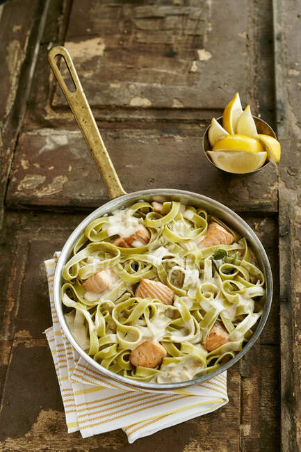 Green tagliatelle with salmon and cheese sauce — Stock Photo