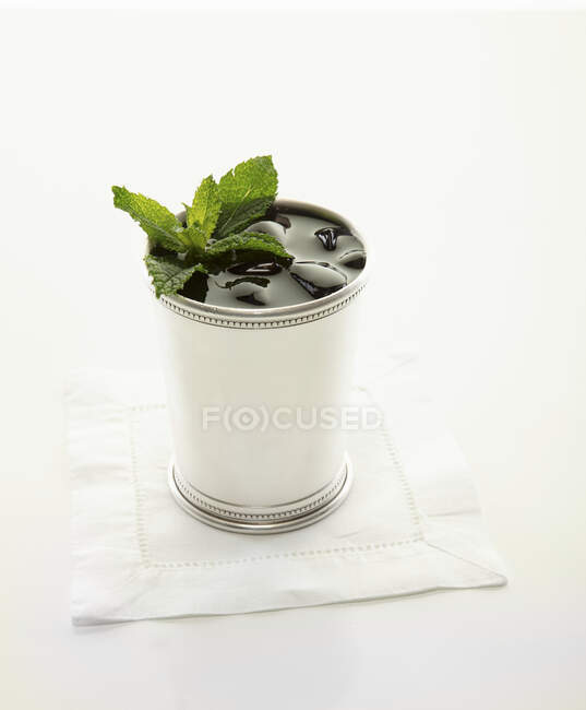 Коктейль монетного джуніпу в срібній чашці, прикрашений листя м'яти — стокове фото