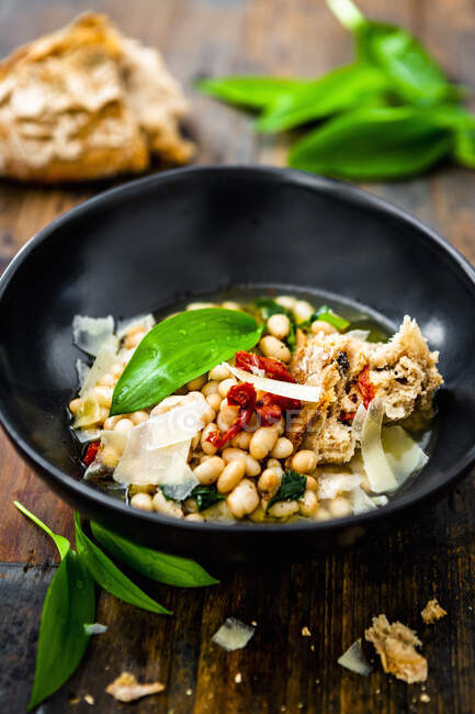White beans with wild garlic, dried tomatoes and bread — Stock Photo