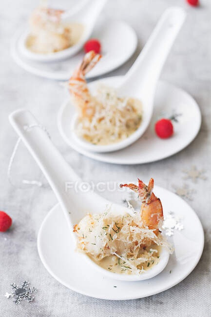 Crevettes frites en sauce sur des cuillères en porcelaine — Photo de stock