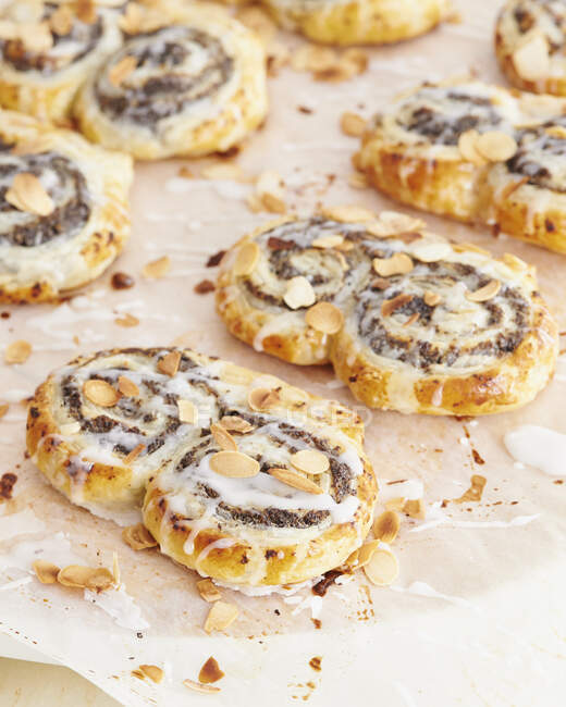 Poppy seed puff pastry buns with icing and flaked almonds — Foto stock