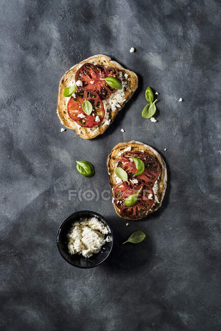 Bruschetta with riccotta cheese, kumato tomatos, basil, olive oil, salt and black pepper — Stock Photo
