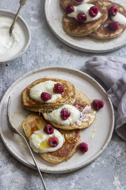 Banana and yogurt pancakes with yogurt, honey and raspberries — Stock Photo