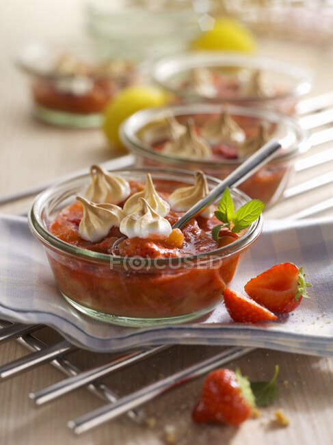 Strawberry and rhubarb dessert served in glass bowl with meringues — Stock Photo