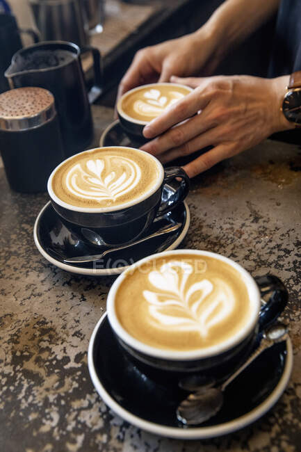 Cappuccinos com padrões de espuma de leite — Fotografia de Stock