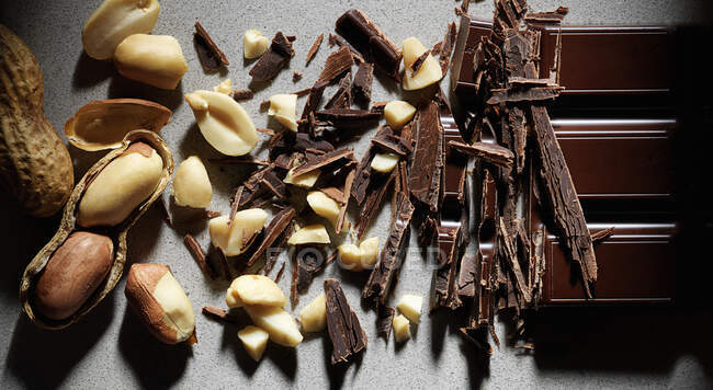 Bar de chocolate y cacahuetes se reúnen en el medio - foto de stock