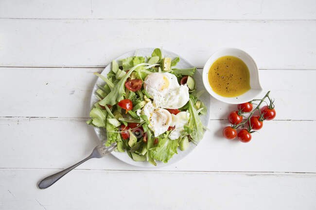Lettuce with poached eggs and cherry tomatoes — Stock Photo