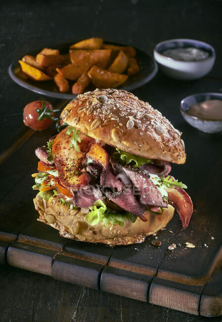Um hambúrguer com carne assada, lagosta e fatias de batata — Fotografia de Stock