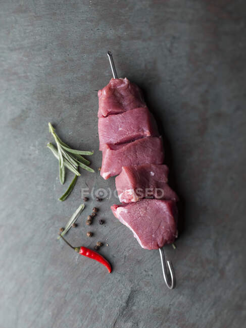 Raw meat skewer on grey background — Stock Photo