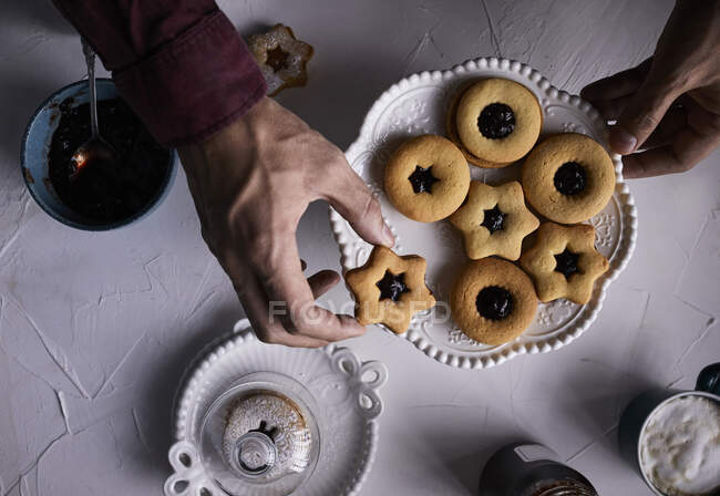 Placing Linzer cookie on a plate — Stock Photo