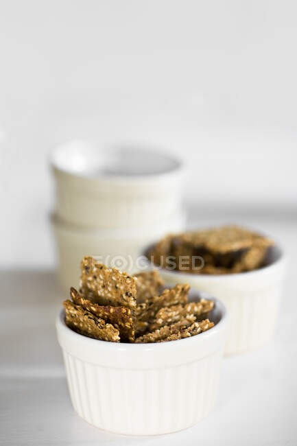 Linen crackers in small ceramic bowls — Stock Photo