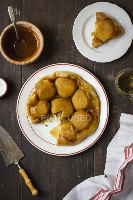 Tarte tartin com maçãs e caramelo salgado, sal, caramelo em um bawl, xícara de chá — Fotografia de Stock