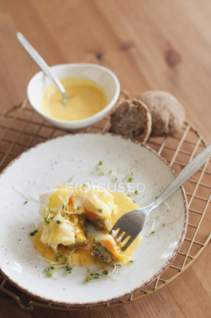 Uova in camicia Benedetto su fetta di pane con forchetta sul piatto — Foto stock