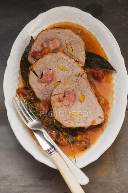 Roulade de cerdo relleno en un caldo de verduras - foto de stock