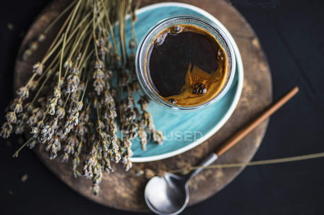 Ein Glas Kaffee mit getrockneten Lavendelblüten — Stockfoto