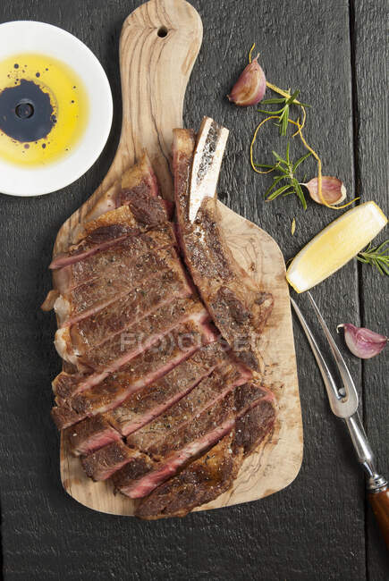 Carved ribeye steak on cutting board — Stock Photo