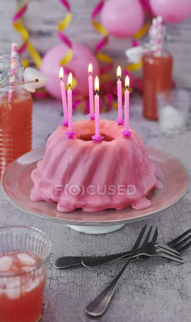 Рожевий торт на день народження зі свічками — стокове фото