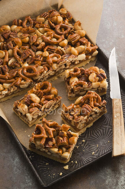 Pecan macadamia slices with pretzels and caramel — Stock Photo