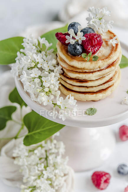Pancakes stack with raspberries, blueberries, mint and lilac — Stock Photo