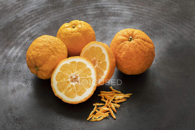 Naranjas amargas frescas con ralladura en metal negro - foto de stock