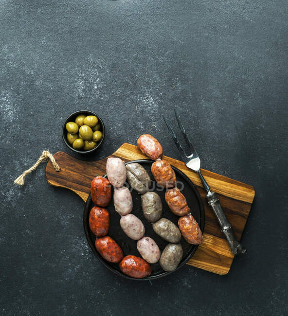 Embutidos españoles en la tabla de cortar (butifarra blanca, chorizo, morcilla de cebolla) - foto de stock