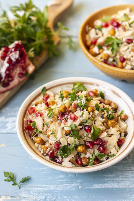 Cauliflower cous cous with chickpeas, pomegranate, almond flakes and parsley — Stock Photo