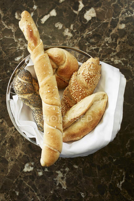 Ein Korb Brot auf einem Marmortisch — Stockfoto