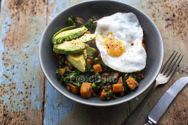 Gebratenes Ei mit Avocado und Grünkohl-Butternuss-Kürbis-Hasch — Stockfoto