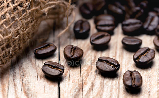 Roasted coffee beans on a wooden surface (close-up) — Photo de stock