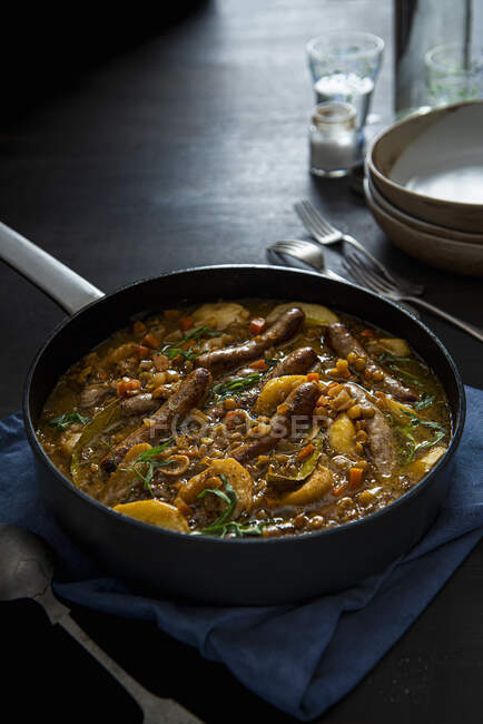 Sausage casserole cooked in cider with lentils apples and tarragon — Stock Photo