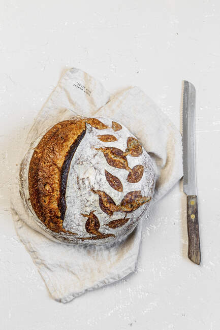 Round sourdough loaf on white background — Stock Photo