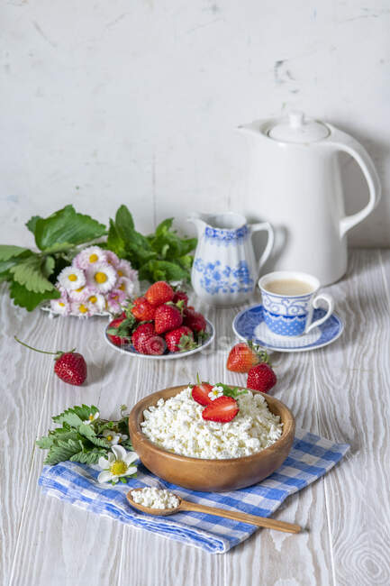 Cottage cheese with fresh strawberries and flowers — Stock Photo