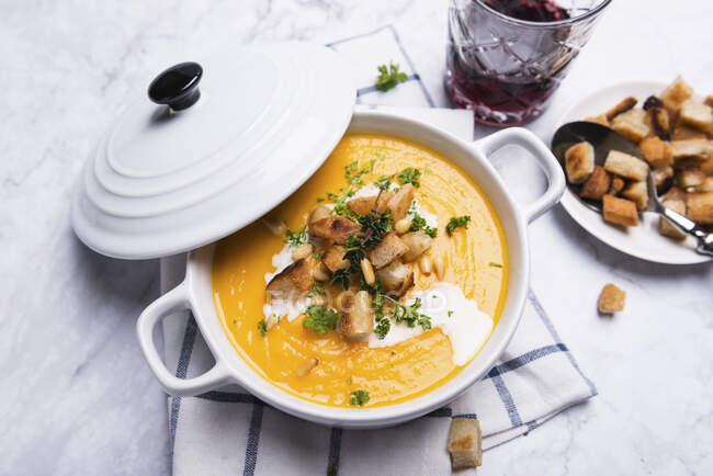Möhren-Pastinaken-Suppe mit Croutons, Pinienkernen und Kräutern — Stockfoto