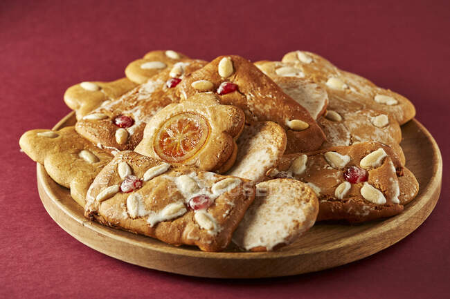 Verschiedene Kekse mit Beeren, Zitrusscheiben und Nüssen auf dem Teller — Stockfoto