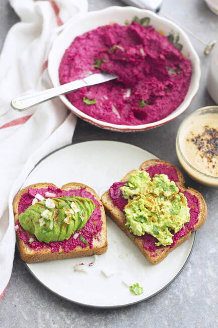 Rote-Bete-Hummus und Avocado-Püree auf Toast — Stockfoto
