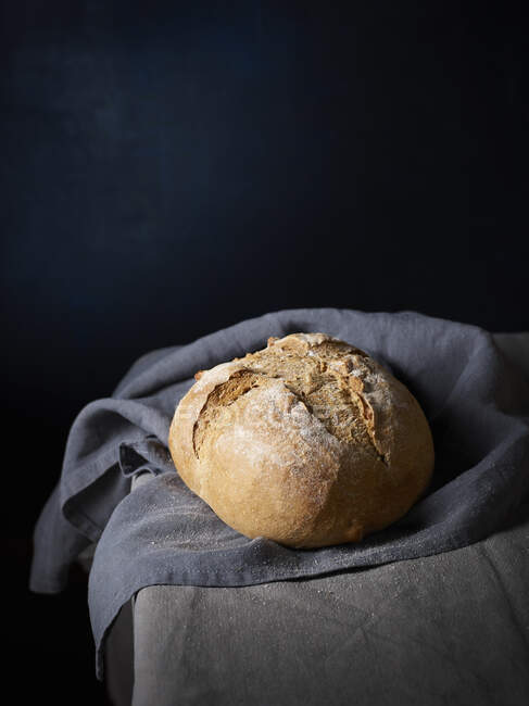 Wholegrain bread loaf on dark cloth — Stock Photo
