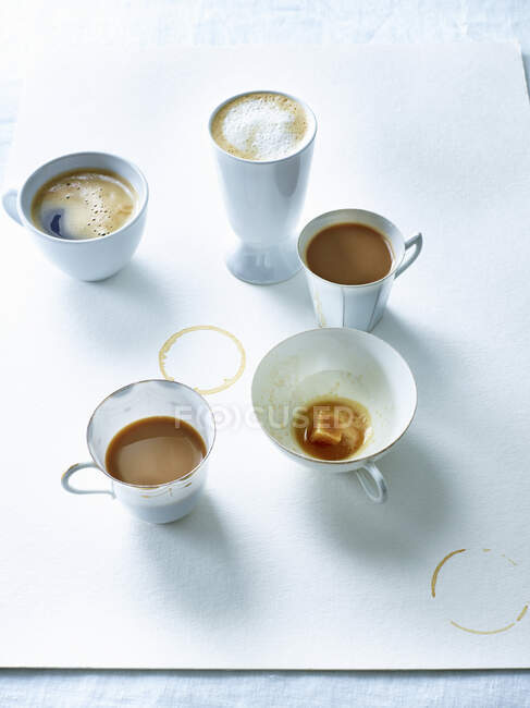 Tazas de café en hoja de papel blanco - foto de stock