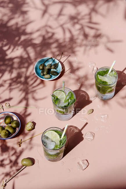 Mojito coctails in a sunshine with capers and olives — Stock Photo