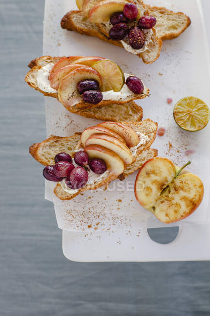Хлебные тосты с виноградом, яблочными ломтиками и маскарпоном — стоковое фото