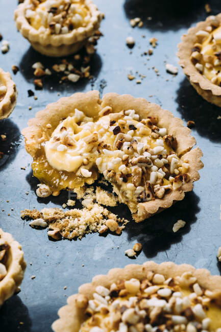 Shortcrust pastry custard tarts with a rhubarb and ginger conserve filling and toasted chopped nut topping — Stock Photo