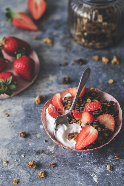Granola com iogurte e morangos em tigela rústica — Fotografia de Stock
