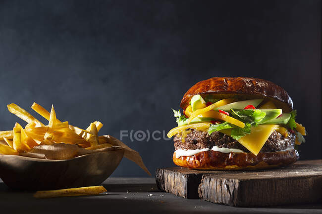 Burger con mango e avocado, servito con patatine fritte — Foto stock