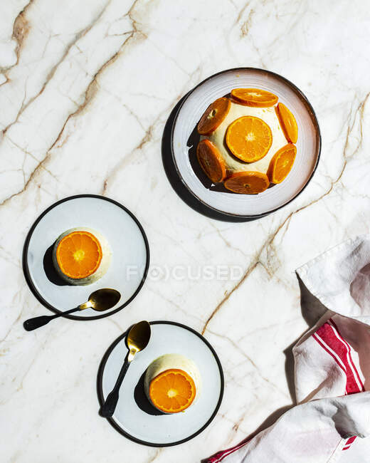 Citrus Panna cotta mit Mandarinenscheiben auf Marmoroberfläche — Stockfoto