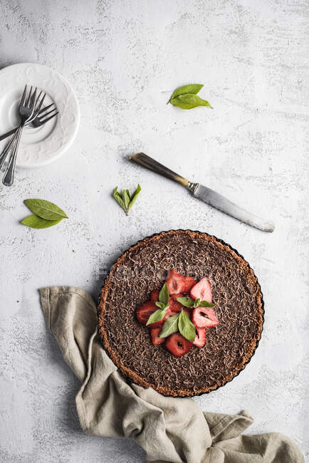 Chocolate tart with strawberries and mint leaves — Stock Photo