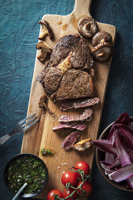 Ribeye-Steak mit Chimichurri-Sauce, Pilzen und Salat — Stockfoto